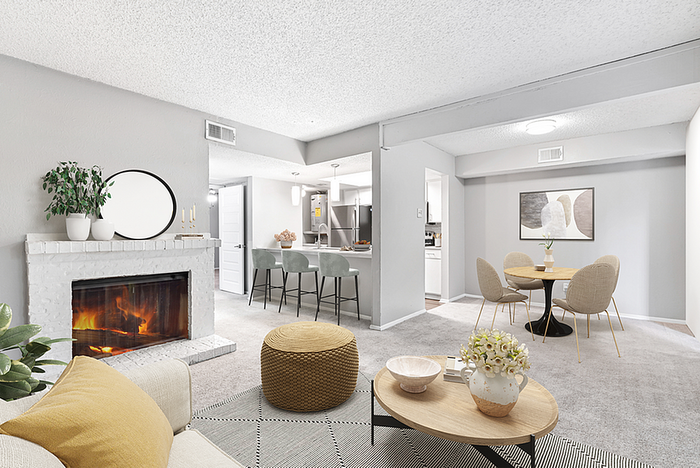 Inviting open-concept living space with cozy fireplace, modern kitchen with sleek barstools, and elegant dining area.