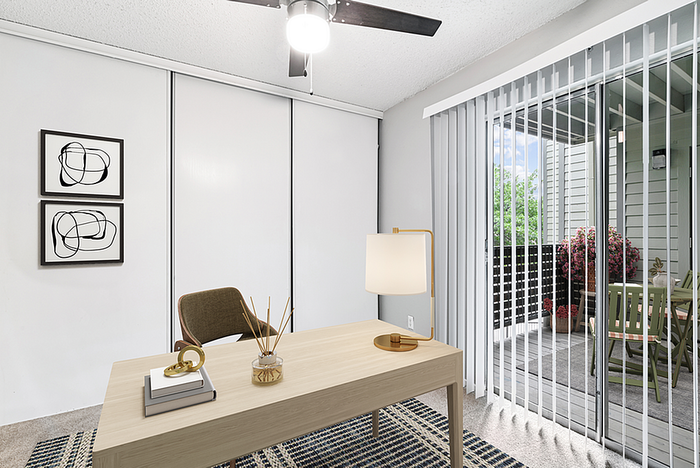 Bright home office with modern decor, featuring a sleek wooden desk, stylish chair, and access to a lush balcony with outdoor seating.