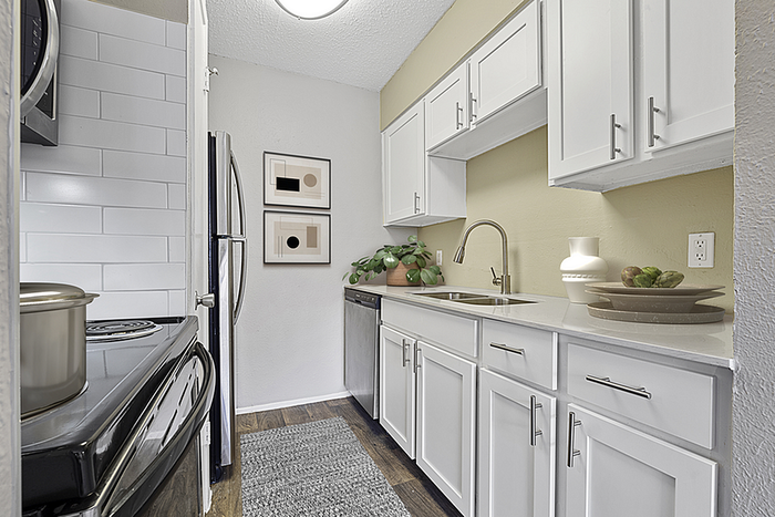 Modern kitchen featuring sleek white cabinetry, stainless steel appliances, and elegant decor accents, perfect for culinary creativity.
