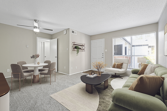 Chic and cozy living room with plush green sofa, modern dining set, and large window flooding the space with natural light.