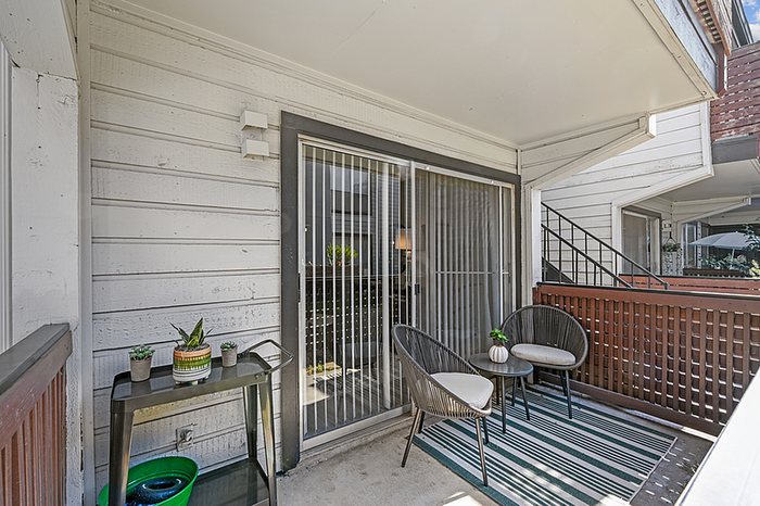 Charming balcony space with stylish furniture, accent plants, and a cozy ambiance for relaxation.