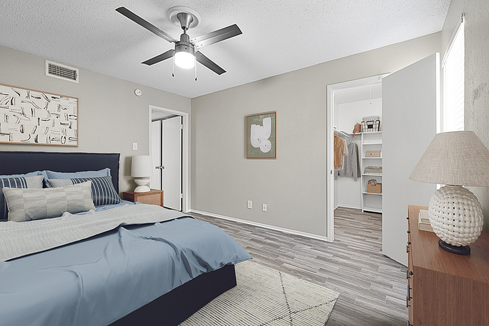 Chic bedroom with modern ceiling fan, stylish decor, and spacious walk-in closet.