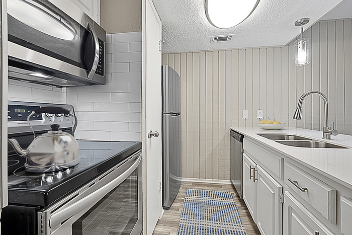 Modern kitchen with sleek stainless steel appliances, elegant white cabinets, and a stylish subway tile backsplash.