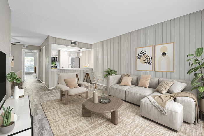 Stylish open-concept living room with modern decor, featuring a cozy gray sofa, elegant armchair, and chic kitchen with bar seating.