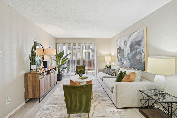 Bright and inviting living room with modern decor, featuring a comfortable sofa, stylish artwork, and large windows with natural light.