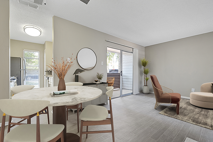 Modern apartment interior showcasing a stylish dining area with a marble table, open-concept living space with chic seating, and abundant natural light from sliding glass doors.