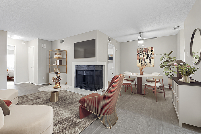 Modern open-concept living and dining area featuring a cozy fireplace, elegant furniture, and stylish decor, creating a warm and inviting atmosphere.
