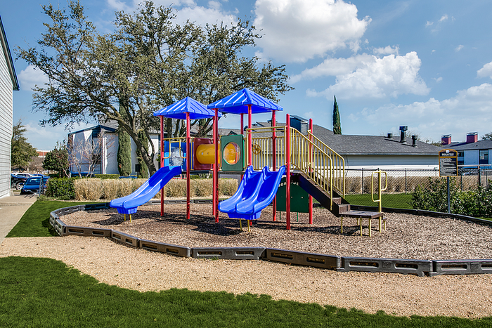 Vibrant playground with colorful slides and climbing equipment set in a sunny, family-friendly community.