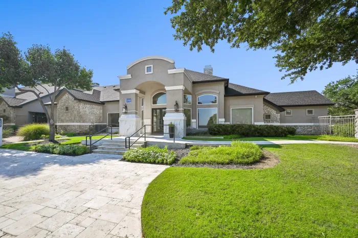 Exterior of the community leasing office featuring stone accents, landscaped grounds, and a welcoming entrance.
