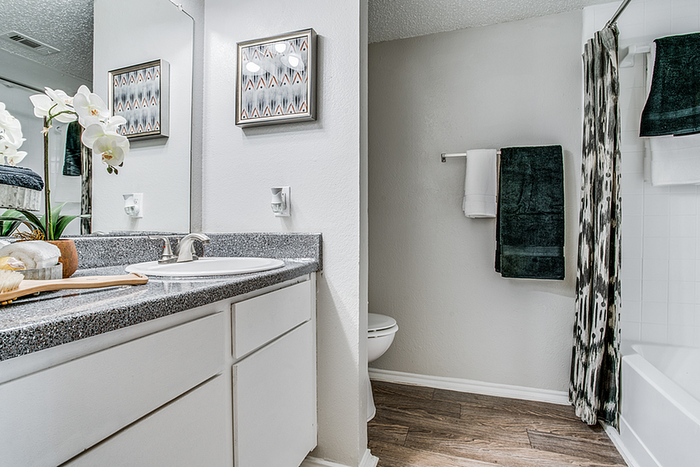 Elegant bathroom featuring a modern vanity with beautiful orchids, sleek countertops, and stylish decor accents.