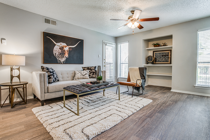 Chic living room featuring modern decor, plush sofa, and stylish artwork, with ample natural light and elegant flooring.