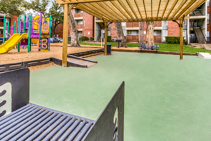 Inviting outdoor area with a vibrant playground and shaded seating, perfect for families to enjoy sunny days.