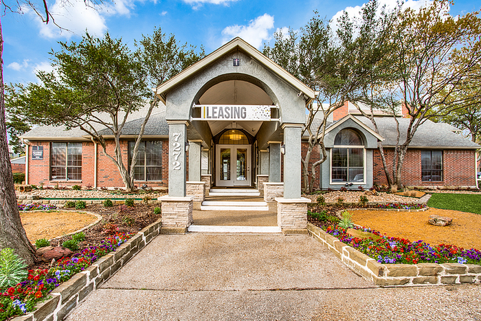 Inviting leasing office entrance with charming brick facade, manicured landscaping, and welcoming signage.