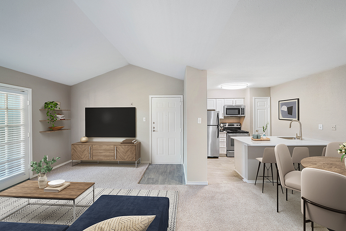 Modern living room and kitchen with open layout, featuring sleek furniture, natural light, and contemporary decor.