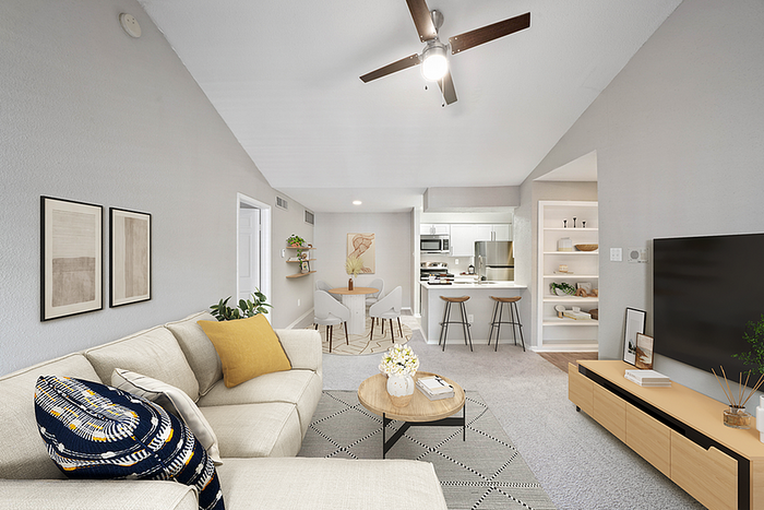Modern living room with cozy furniture, stylish decor, and open kitchen, featuring elegant lighting and neutral tones.