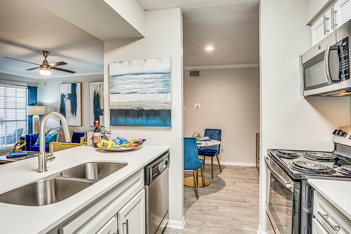 Stylish kitchen view with modern appliances, elegant dining area, and vibrant decorations bathed in natural light.