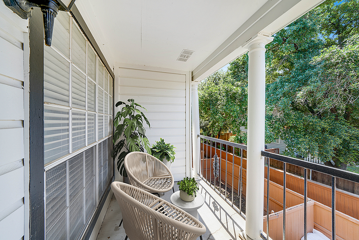 Charming outdoor balcony with cozy seating and lush views, perfect for relaxation.
