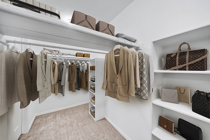 Luxurious walk-in closet featuring neatly organized clothing and stylish accessories, perfect for fashion lovers.