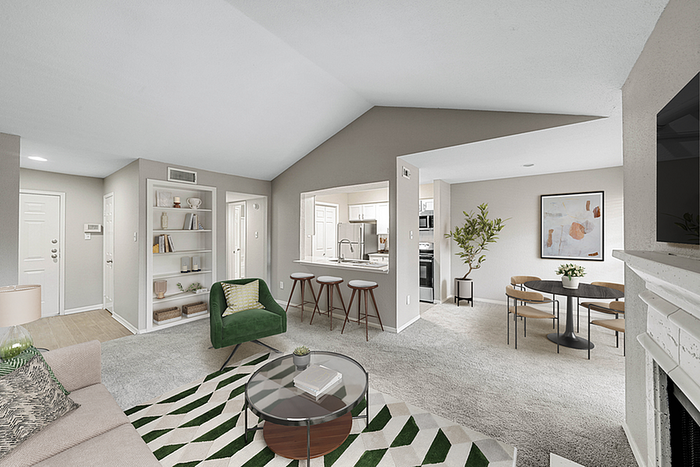 Inviting open-concept living room with modern decor, cozy fireplace, and a chic dining area connected to a sleek kitchen with bar seating.