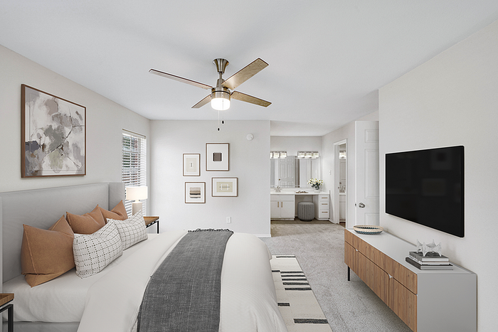 Elegant bedroom with plush pillows, modern decor, and ensuite bathroom featuring stylish vanity and ambient lighting.