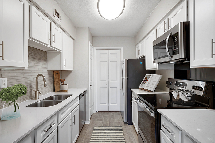 Sleek modern kitchen with white cabinets, stainless steel appliances, and elegant countertops.