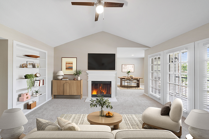 Bright and inviting living room with cozy fireplace, elegant open-concept design, large windows, and modern furnishings.