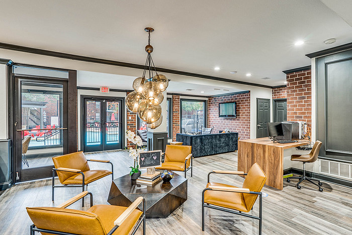 Modern clubhouse with elegant lighting, stylish seating, and large windows providing a bright, inviting atmosphere.