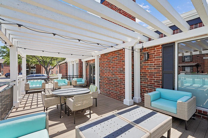 Charming outdoor patio with modern wicker furniture and vibrant turquoise cushions, under a stylish pergola.