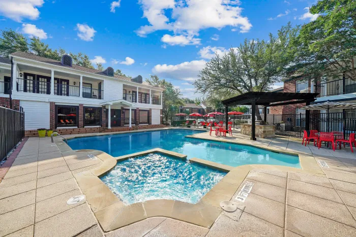 Luxurious apartment community with a swimming pool, spacious sun deck, and vibrant outdoor seating area for relaxation.