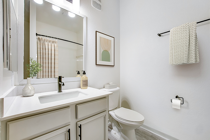 Elegant bathroom with modern white vanity, stylish black fixtures, and soft ambient lighting.