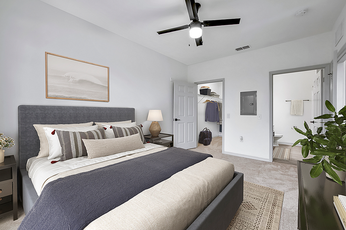 Inviting bedroom with modern decor, plush bedding, ceiling fan, walk-in closet, and en-suite bathroom.