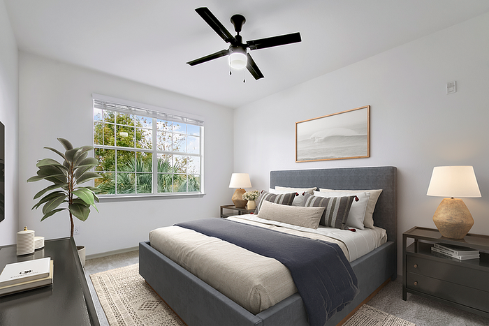 Bright and inviting bedroom with modern decor, featuring a large window, elegant ceiling fan, and chic bedside lamps.