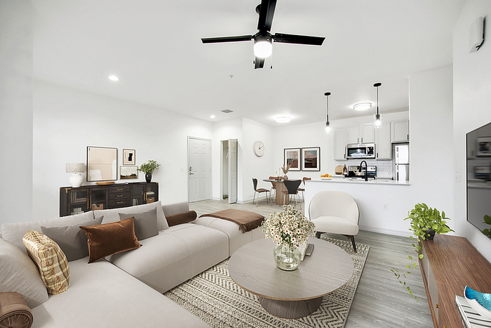 Modern open-concept living room and kitchen with chic furniture, elegant lighting, and stylish decor, offering a warm and inviting ambiance.