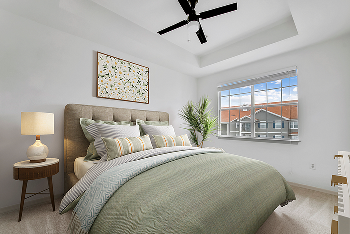 Bright and inviting bedroom with modern decor, stylish headboard, and large window offering a stunning view of the neighborhood.