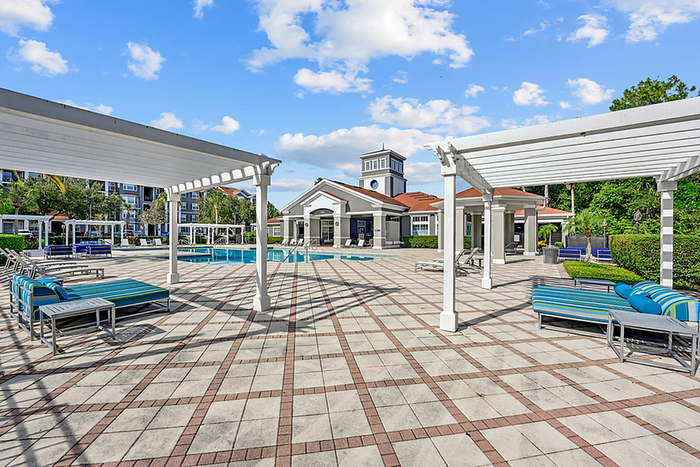 Elegant outdoor area with inviting pool, stylish sun loungers, and chic pergolas, ideal for relaxation.
