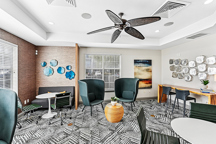 Chic and modern clubhouse area with stylish seating, artistic wall decor, and natural lighting, perfect for relaxation and social gatherings.