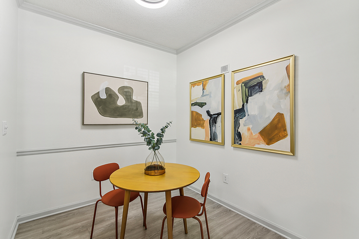 Chic dining nook with vibrant abstract art, featuring a cozy round table and modern decor.