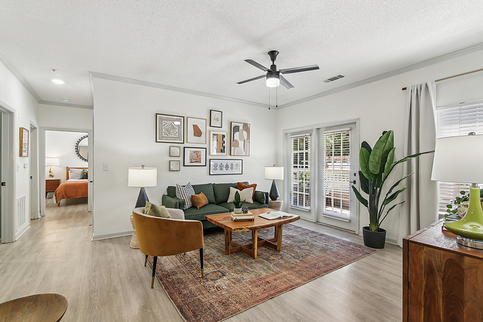 Chic living room featuring elegant decor, stylish furniture, and ample natural light, with a seamless flow into a cozy bedroom.