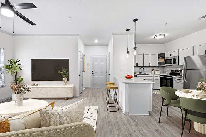 Modern open-concept living space with a cozy seating area, sleek kitchen with bar seating, and stylish contemporary decor.