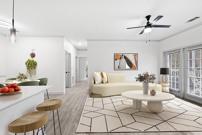 Modern apartment interior showcasing an inviting open-concept living area with stylish furnishings, natural light, and a cozy kitchen nook.