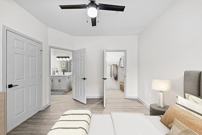 Elegant bedroom view featuring a spacious walk-in closet, modern en-suite bathroom, and calming neutral decor.