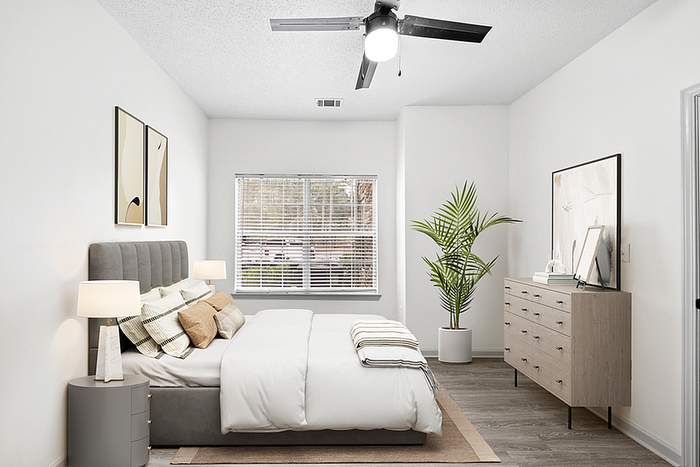 Bright and inviting bedroom with modern decor, featuring a plush bed, elegant bedside lamps, and a large window overlooking greenery.