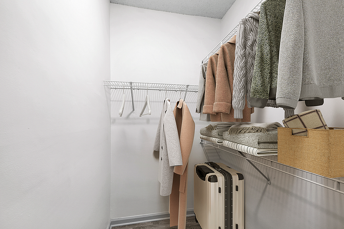 Spacious and organized walk-in closet with modern shelving, showcasing cozy sweaters, coats, and neatly folded blankets.