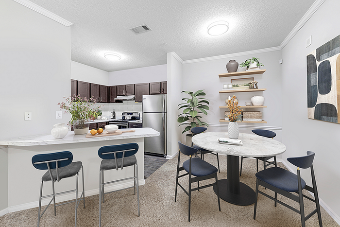 Chic apartment kitchen with sleek stainless steel appliances, a stylish breakfast bar, and an elegant dining area with modern decor.