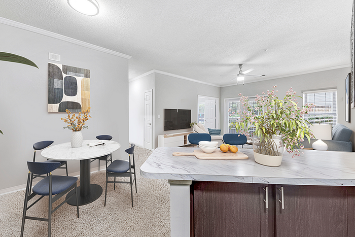 Bright, open-concept living space featuring modern dining area, elegant marble island, and cozy seating with abundant natural light.
