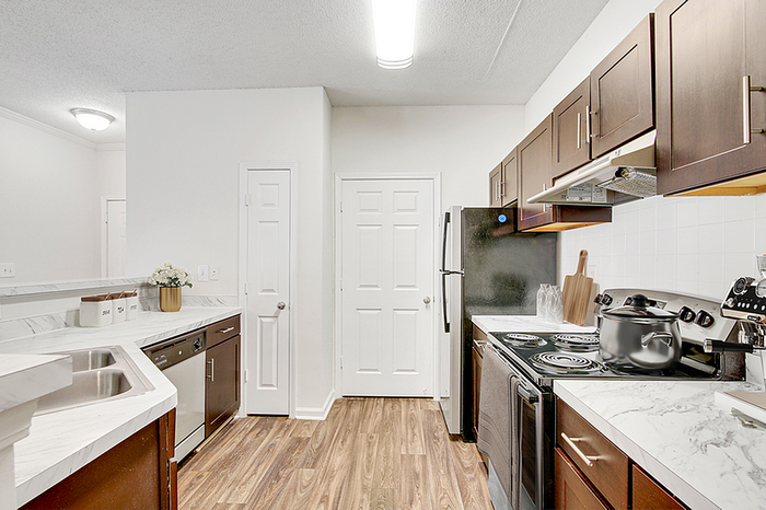 Modern kitchen with elegant marble countertops, sleek dark wood cabinets, and stainless steel appliances, perfect for culinary enthusiasts.