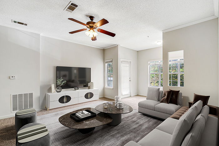Inviting living room with plush sofas, chic coffee table, and large windows offering abundant natural light.