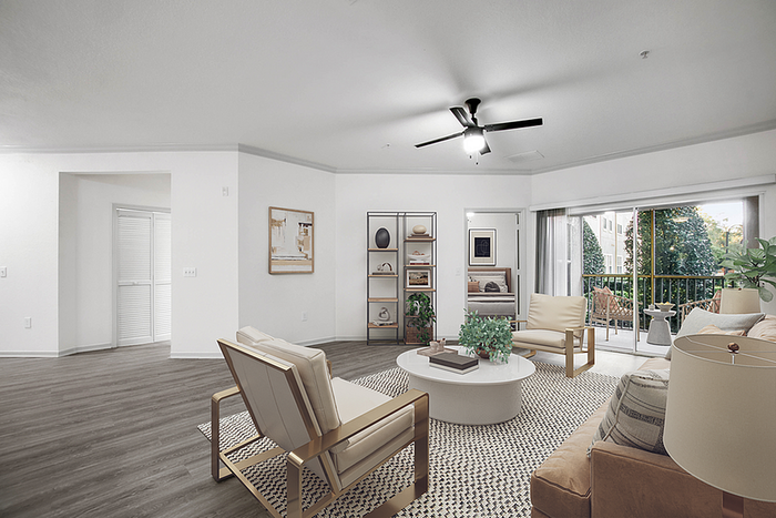 Chic open-concept living room with modern furniture, elegant decor, and sliding doors leading to a scenic balcony view.