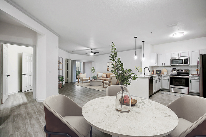 Modern open-concept living area with sleek kitchen, cozy dining space, and inviting lounge, featuring stylish decor and elegant lighting.