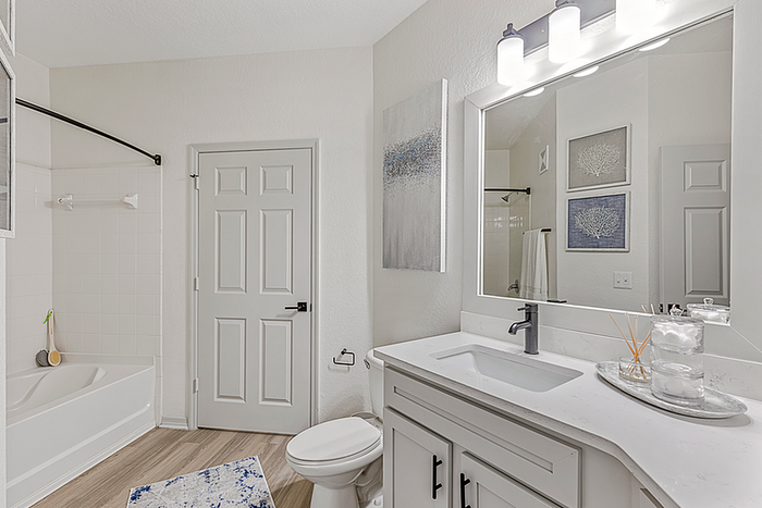 Bright and modern bathroom with sleek fixtures, large mirror, and elegant decor.